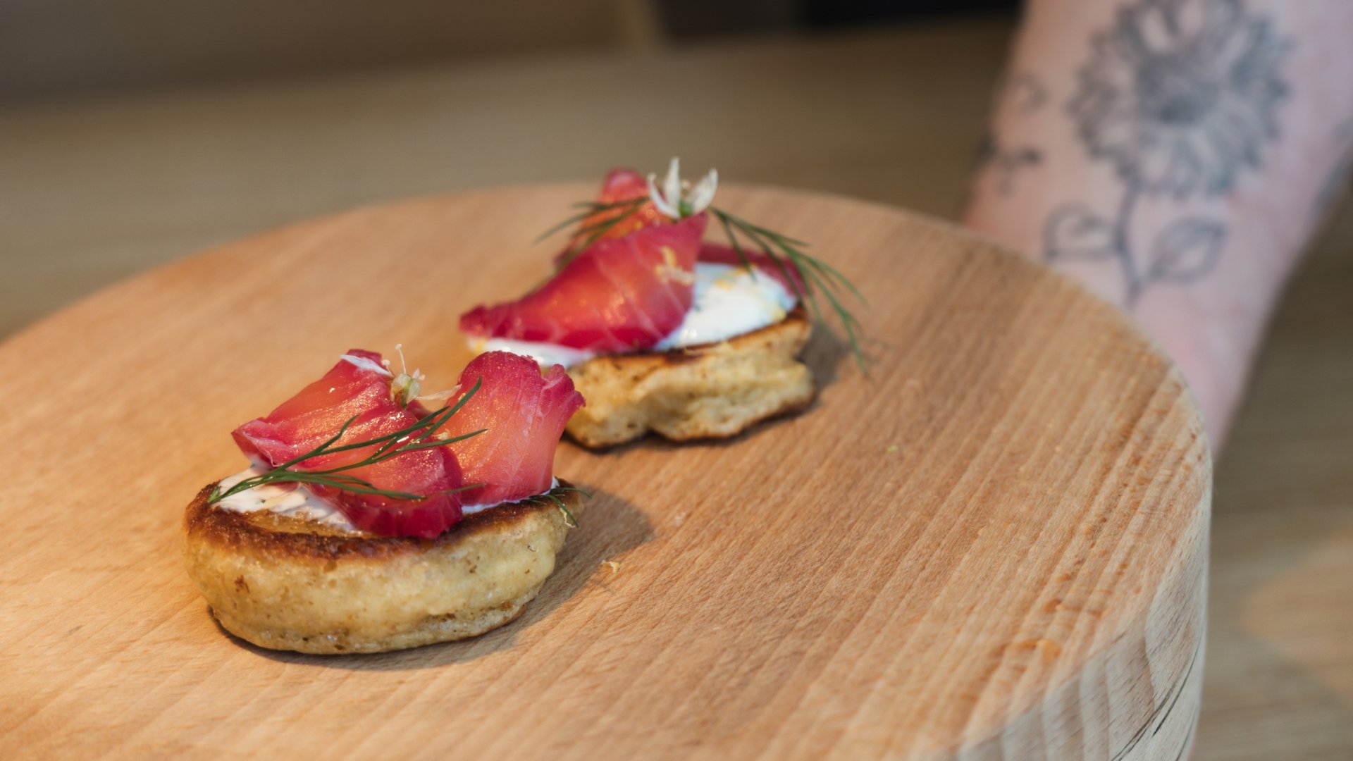 Restaurant in Parsberg: Gourmet genießen Zwei Canapés mit Lachs und Kräutern auf einem Holzbrett