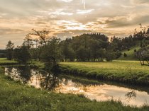 Workation Landschaft mit Fluss, Bäumen und Sonnenuntergang im Hintergrund