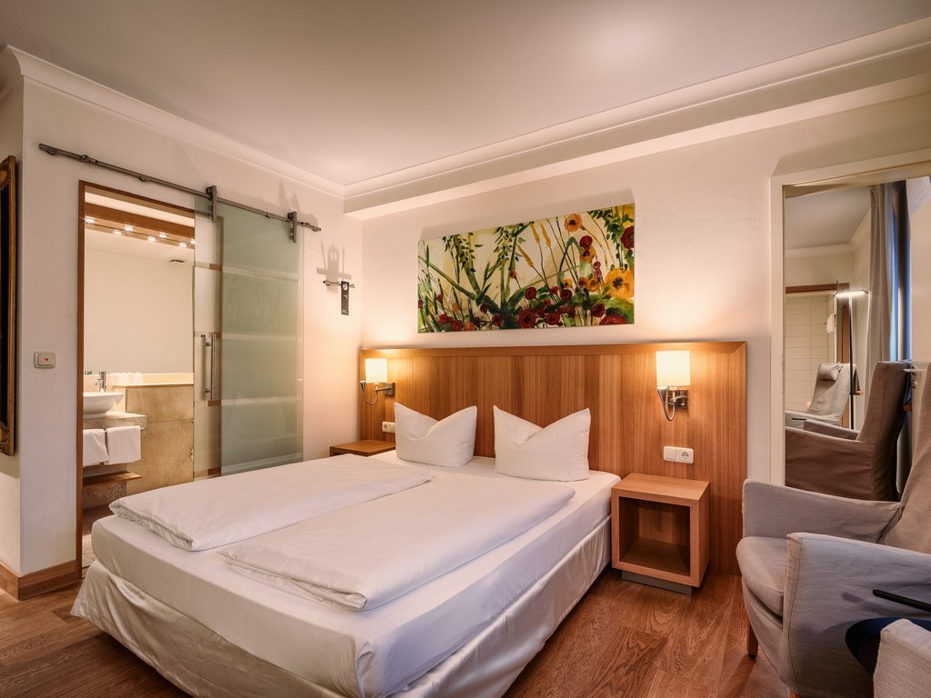 Workation Modernes Hotelzimmer mit Doppelbett, Sessel und Bad mit Glastür
