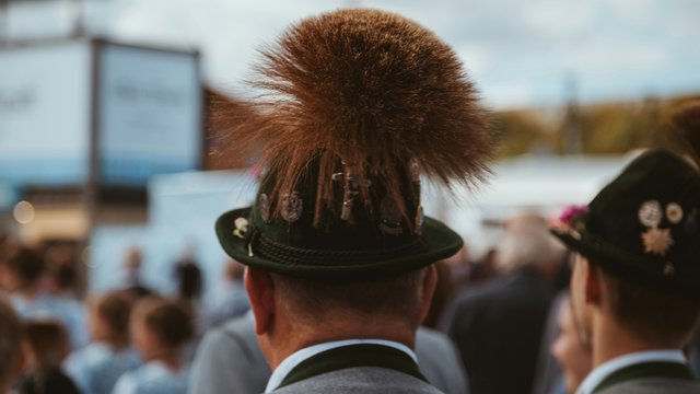 Romantik Hotel Hirschen: Blog Person mit traditionellem Hut und großem braunem Gamsbart auf einer Veranstaltung