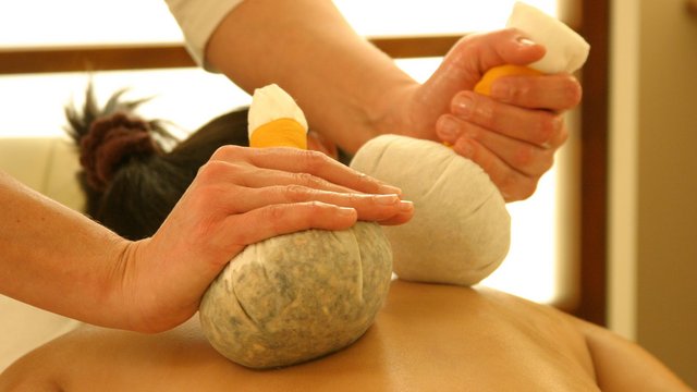 Golf holiday in Bavaria: top boss or beginner? Hot herbal compress massage on a person's back