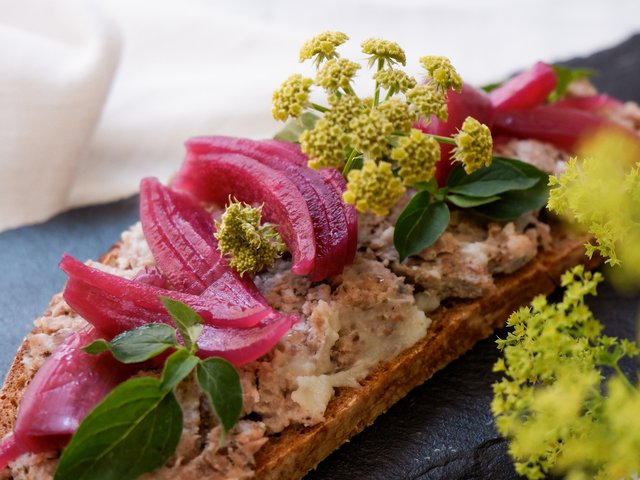 Romantik Hotel Hirschen: Bildergalerie Vollkornbrot mit Aufstrich, roten Zwiebeln, grünen Kräutern und gelben Blüten