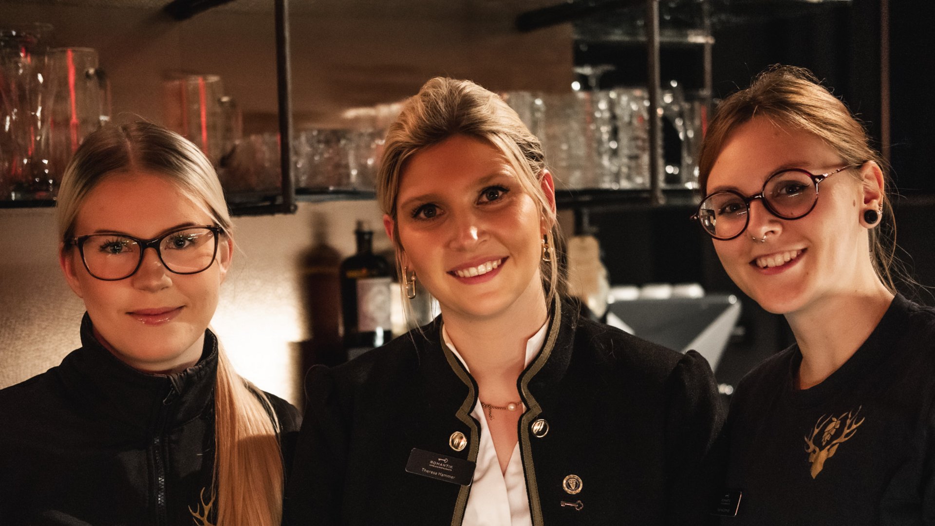 Hirschenblobb Bar in Parsberg: Cocktails, Whisky & regionale Biere Drei lächelnde weibliche Mitarbeiter in einer Bar mit schwarzer Arbeitskleidung