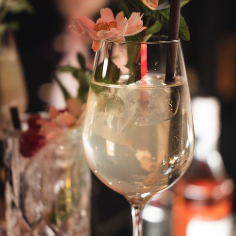Hirschenblobb: Our bar Cocktail with ice and flower garnish in a large wine glass
