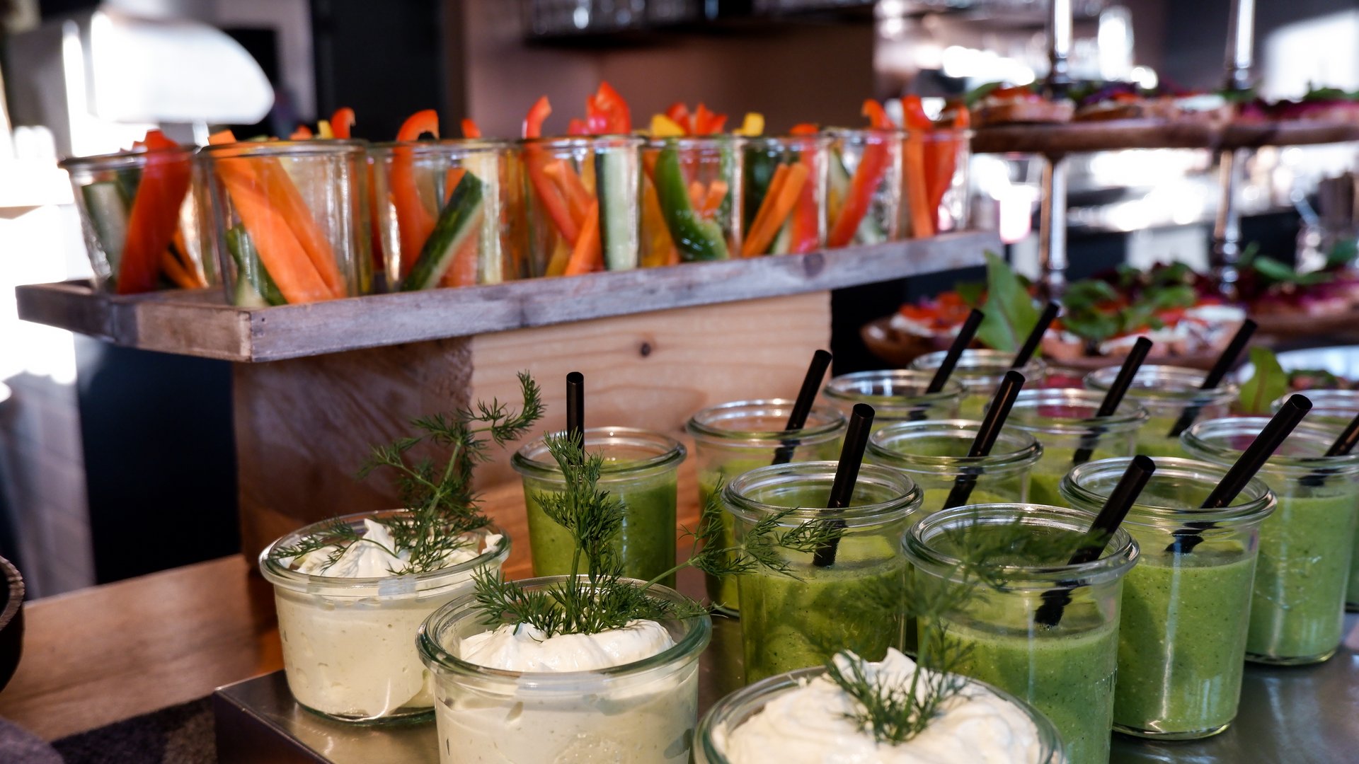 Mental Leadership Retreat Verschiedene Gemüsesticks und grüne Smoothies mit Dips auf einem Buffet