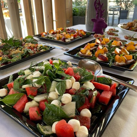 Beer garden in Parsberg: HirschenBlobb Various salads and appetizers on black plates on a table