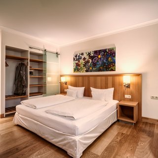 Romantik Hotel in Upper Palatinate: Come back soon! Modern hotel room with double bed, wooden floor, and open wardrobe