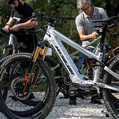Looking for a hotel with bike rental in Bavaria? Two men repairing mountain bikes on a gravel path outdoors