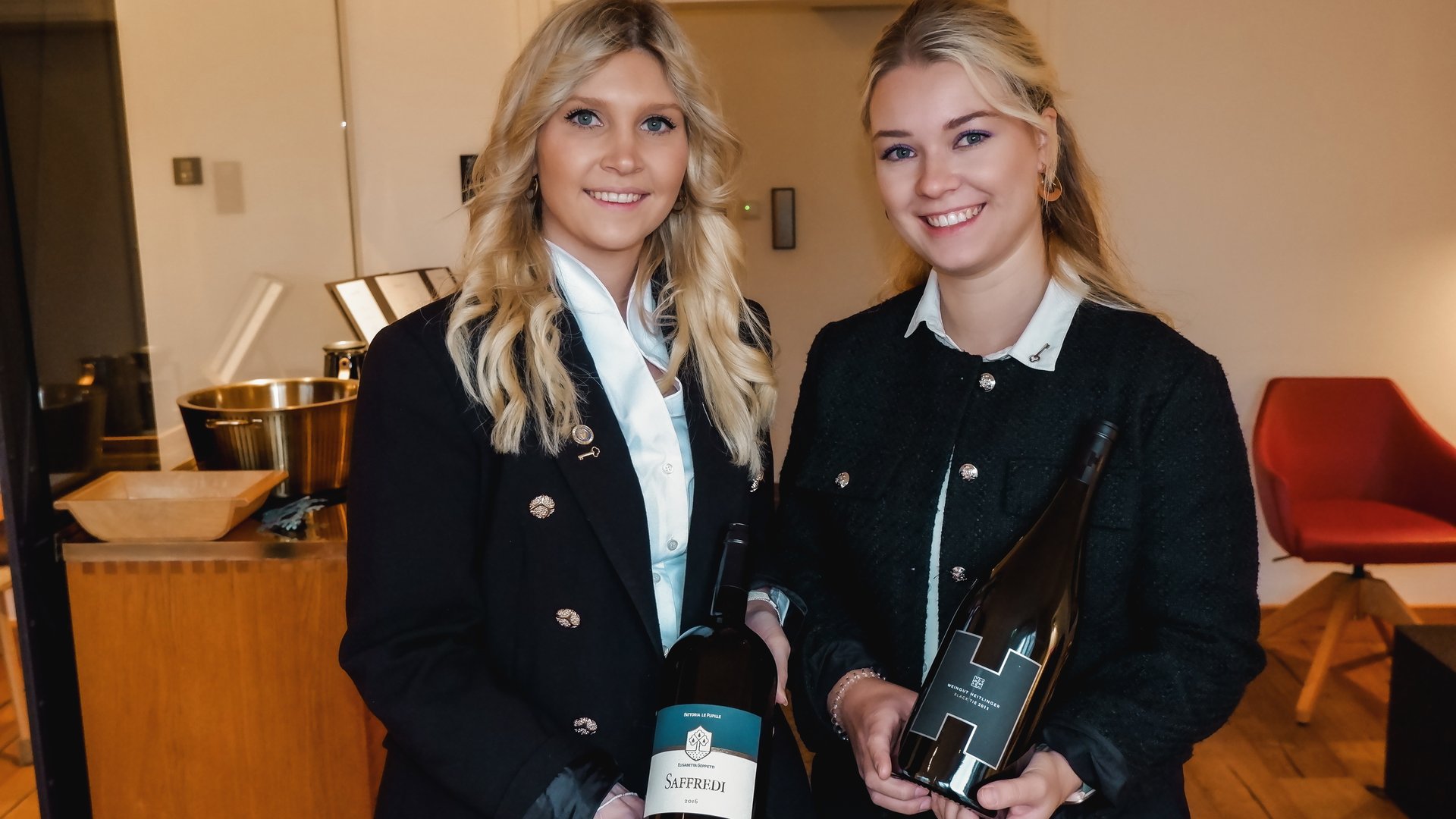 Restaurant in Parsberg: Gourmet genießen Zwei Frauen halten Weinflaschen in einem modernen Innenraum