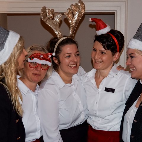 Gasthof Parsberg: Ein Gruß an den guten Geschmack Fünf Frauen mit weihnachtlichen Hüten lachen und umarmen sich