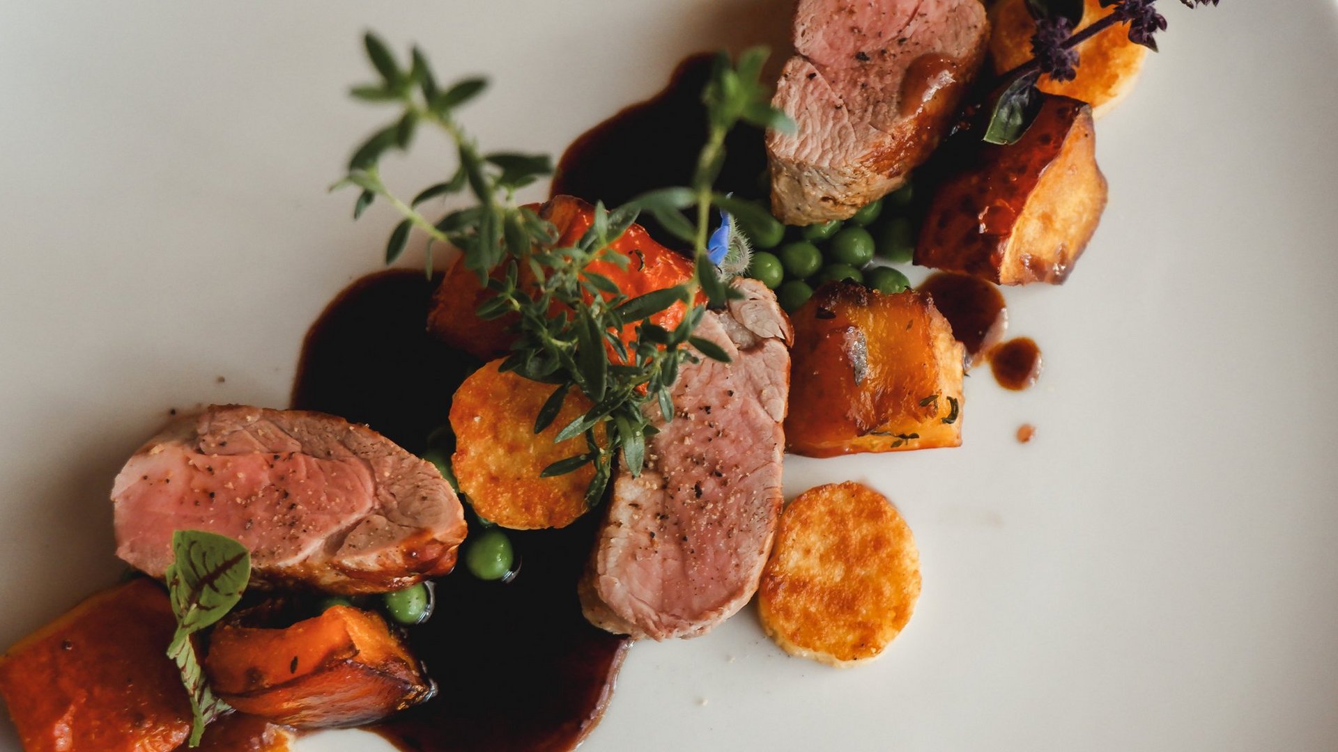 Home Gourmet dish with lamb, sweet potatoes, peas, and herb sauce