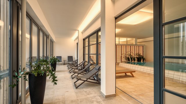 Entspannung in der Oberpfalz: Garten & Ruheräume Modernes Hallenbad mit Liegestühlen und Pflanzen im Entspannungsbereich