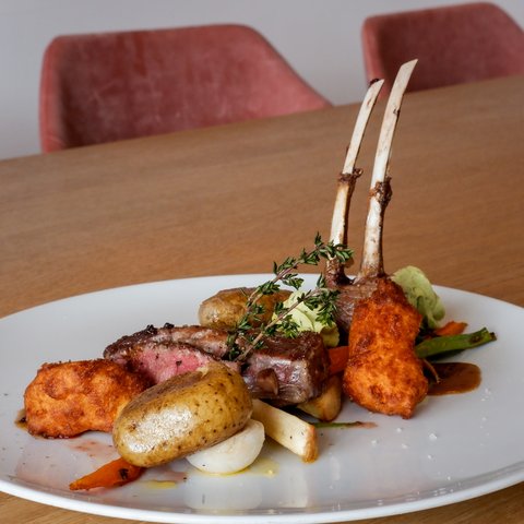 Guesthouse in Parsberg: A salute to great taste Lamb chops with vegetables and potatoes on white plate on wooden table