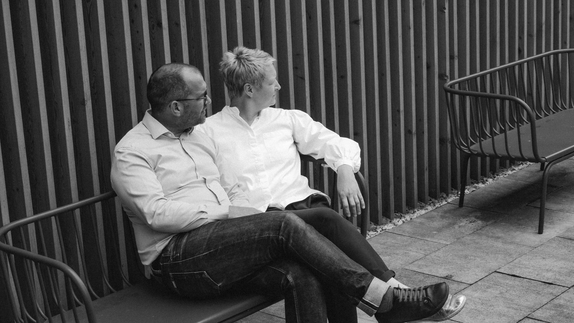 Romantik Hotel in Upper Palatinate: Come back soon! Two people sitting on a bench in front of a wooden slat wall