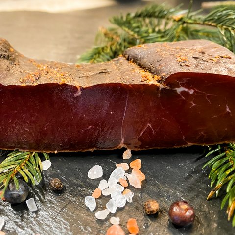 Eco-friendly hotel in Germany with Hirschenmanufaktur A piece of dried meat on pine branches with salt and berries