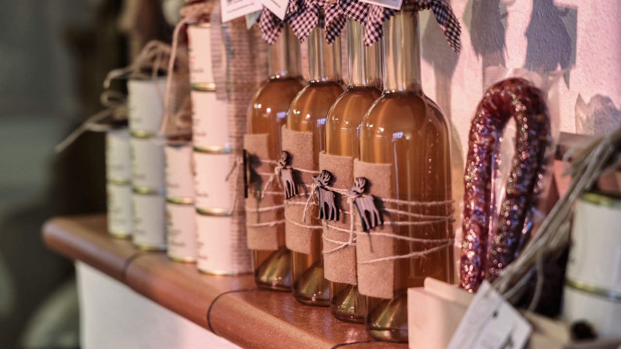 Bottles of liqueur and cans on a wooden shelf