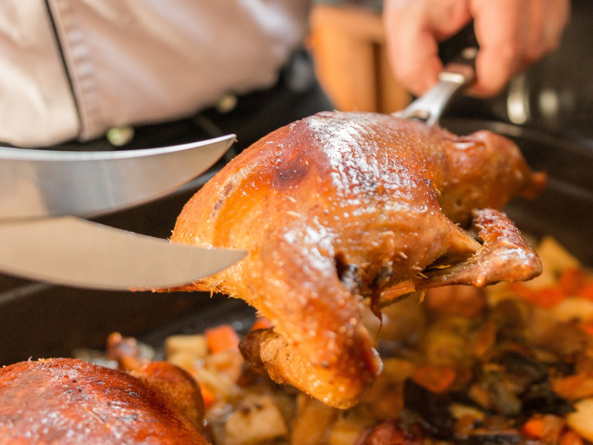Inn & Restaurant in Parsberg serving regional cuisine Roast goose being lifted from pan with knife and fork with vegetables