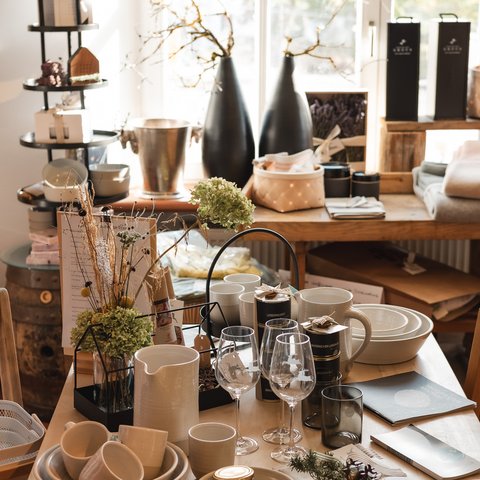 Eco-friendly hotel in Germany with Hirschenmanufaktur Dishes and glasses on wooden table in bright room with decorations