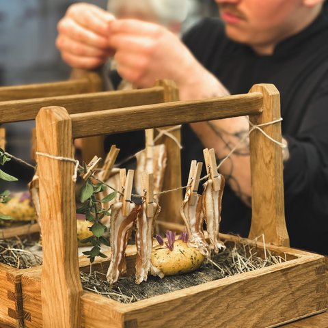 Restaurant in Parsberg: Gourmet genießen Mann dekoriert Speisen mit Holzrahmen und Wäscheklammern