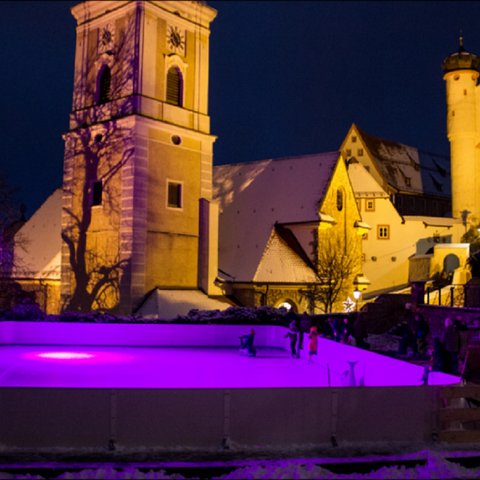 Hotels in Regensburg und Umgebung: kultur-trächtig! Eisbahn mit lila Beleuchtung vor historischen Gebäuden bei Nacht