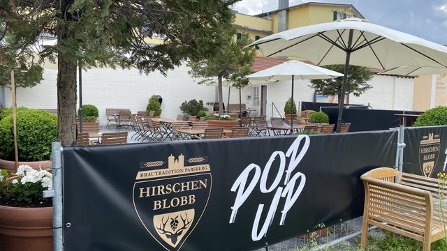 Romantik Hotel Hirschen: Blog Außenbereich eines pop-up Cafés mit Tischen, Stühlen und Sonnenschirmen
