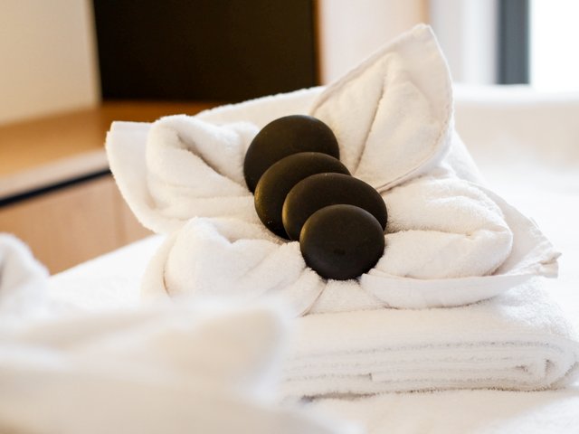 Romantik Hotel Hirschen: Bildergalerie Schwarze Massagesteine auf zusammengerolltem weißen Handtuch