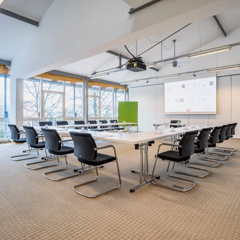 Looking for somewhere for conferences in Bavaria? Bright large conference room with U-shaped tables and projected presentation
