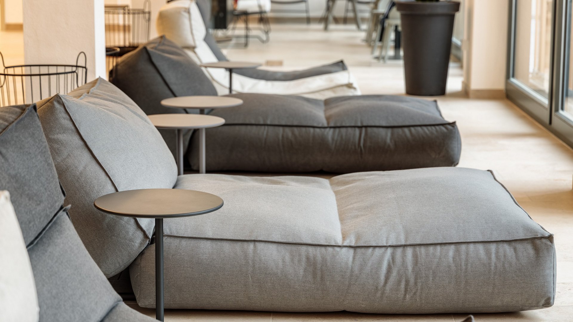 Entspannung in der Oberpfalz: Garten & Ruheräume Moderne graue große Sitzsäcke mit kleinen Beistelltischen in einem hellen Raum