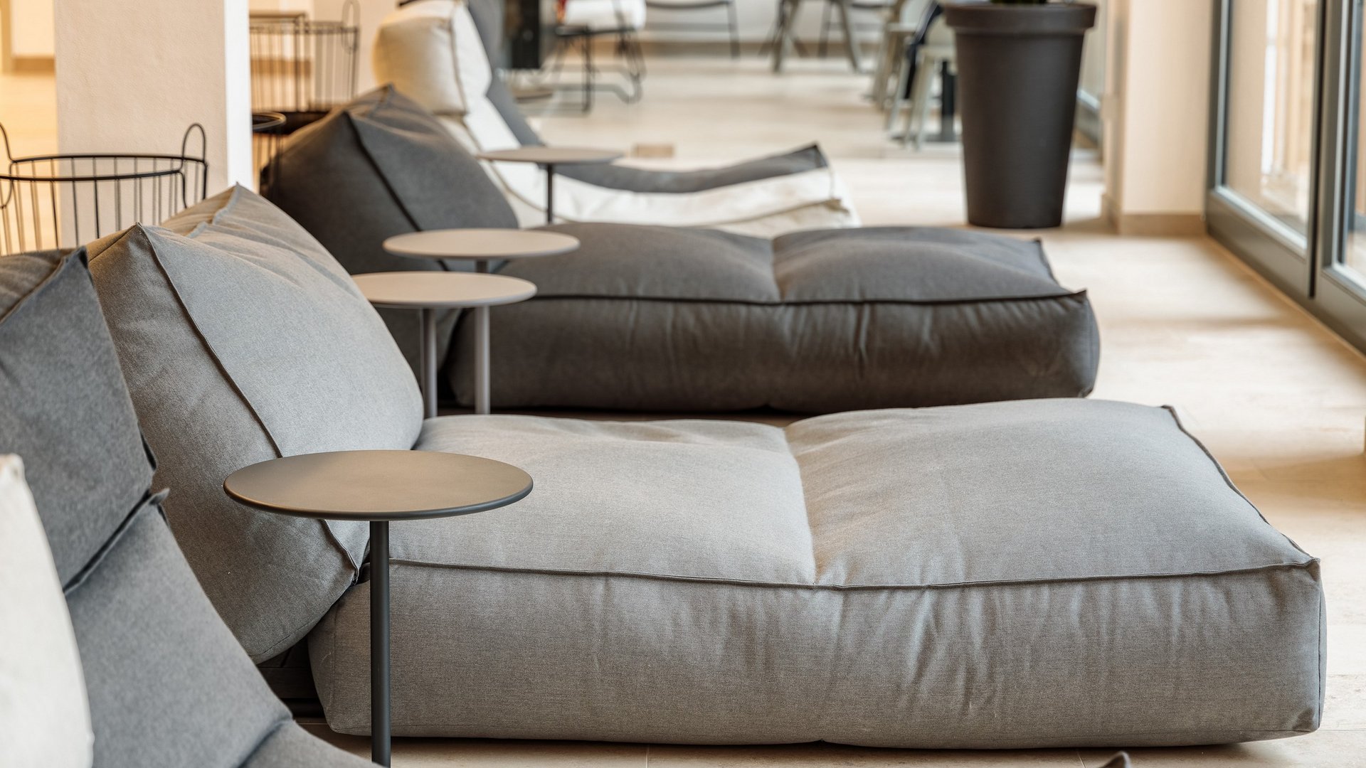 Entspannung in der Oberpfalz: Garten & Ruheräume Moderne graue große Sitzsäcke mit kleinen Beistelltischen in einem hellen Raum