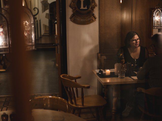 Romantik Hotel Hirschen: Bildergalerie Zwei Personen sitzen bei Kerzenlicht an einem Tisch in einem gemütlichen Raum