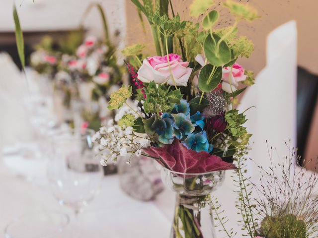 Romantik Hotel Hirschen: Bildergalerie Blumenarrangement mit rosa Rosen und grünen Blättern in Vase auf Tisch