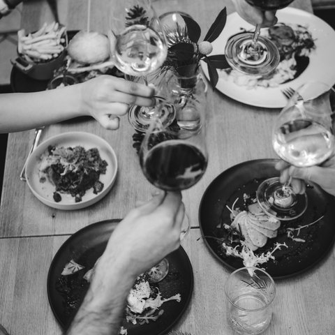 Guesthouse in Parsberg: A salute to great taste People clinking wine glasses at a table set with food