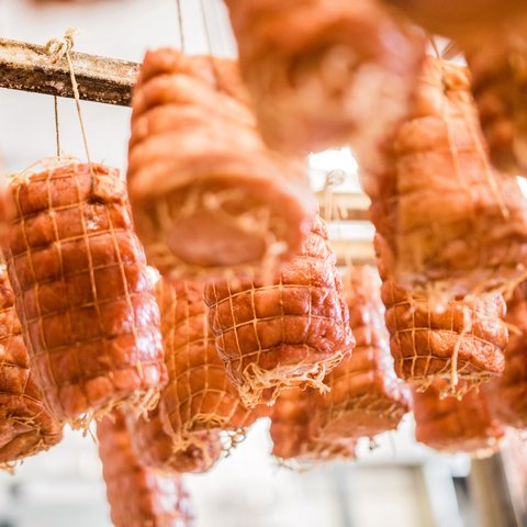 Nachhaltiges Hotel in Bayern mit Hirschenmanufaktur Fleischstücke hängen zum Reifen in einem Räucheraum