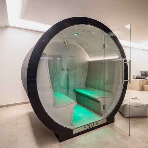 Day wellness in Upper Palatinate Modern sauna cabin with green LED lighting and glass front