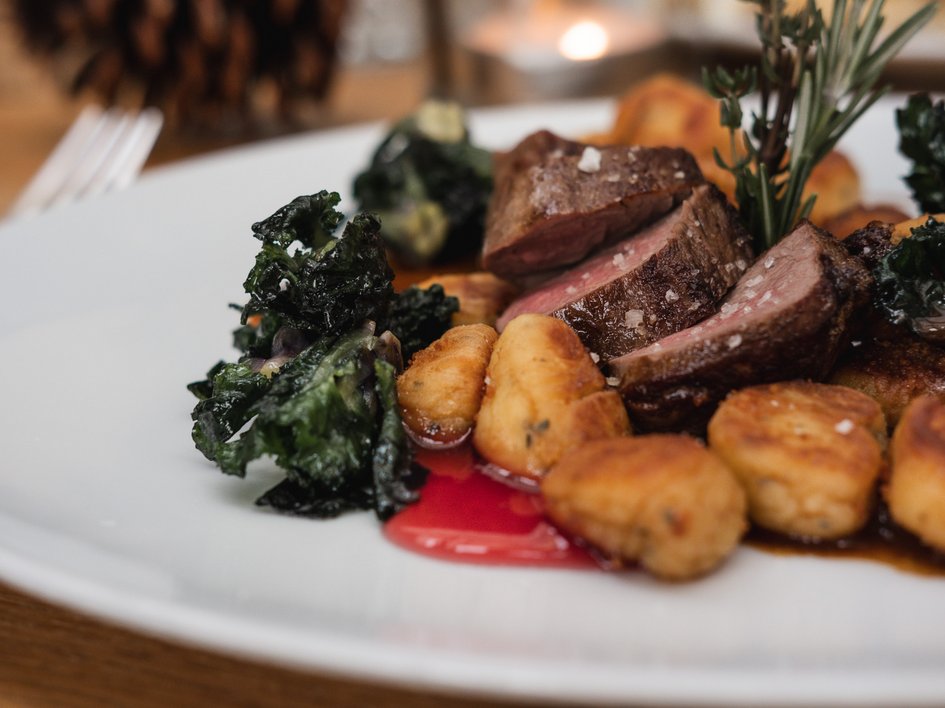 Gasthof Parsberg: Ein Gruß an den guten Geschmack Gebackene Kartoffelgnocchi mit Rindersteak und grünem Gemüse auf weißem Teller