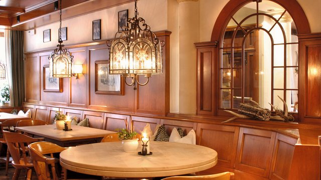 Beer garden in Parsberg: HirschenBlobb Cozy dining room with wooden tables, chairs, and warm lighting