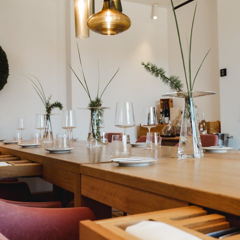 Restaurant in Parsberg: Gourmet genießen Eleganter gedeckter Esstisch mit Gläsern und minimalistischen Blumendekorationen