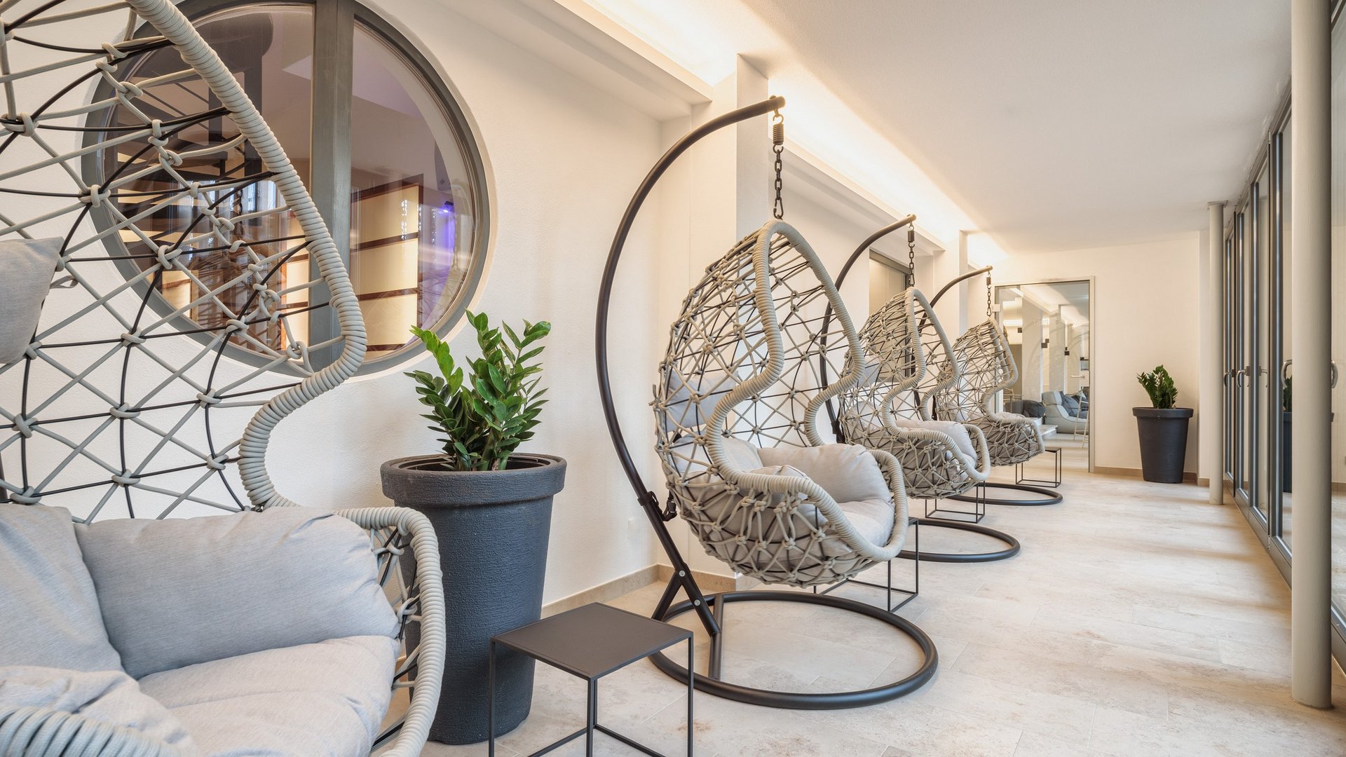 Hotel in Upper Palatinate: Get a breath of holiday air! Modern hanging chairs in bright minimalist interior with plants and a mirror