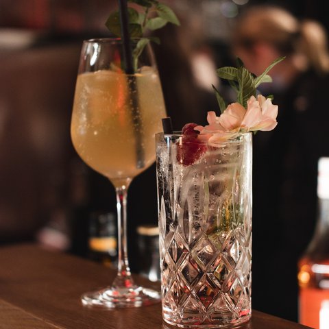 Hirschenblobb: unsere Bar Zwei dekorierte Cocktails auf Holztisch in Bar