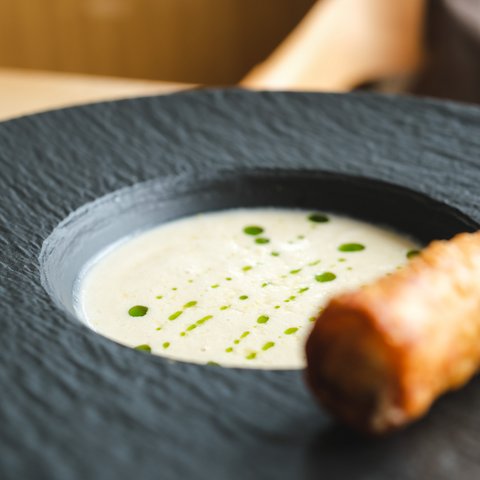 Kulinarik & Genuss in der Oberpfalz Feine Suppe mit grünen Tropfen im schwarzen Teller und geröstetem Brot