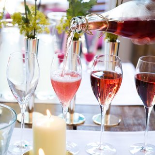 Hochzeitslocation Oberpfalz gesucht? Roséwein wird in Sektgläser auf einem dekorierten Tisch eingeschenkt