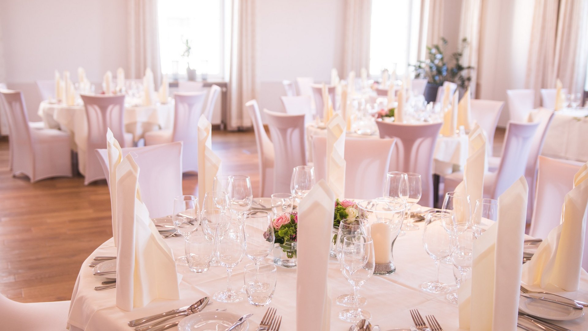 Hochzeitslocation Oberpfalz gesucht? Elegante festliche gedeckte Tische mit weißen Servietten und Blumen