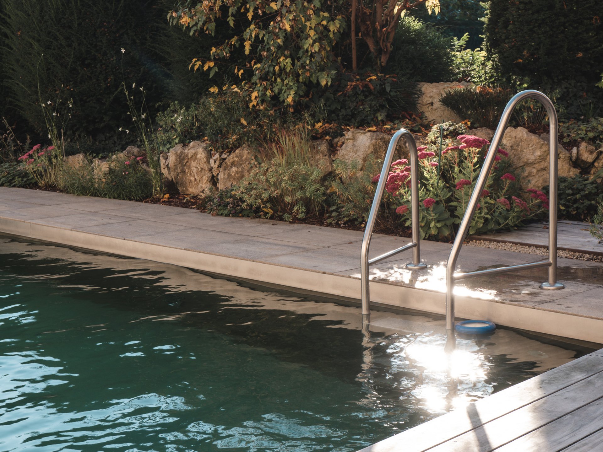 Wellness Oberpfalz – GartenSPA im Romantik Hotel Hirschen Pool ladder beside the water, with a landscaped garden and pink flowers