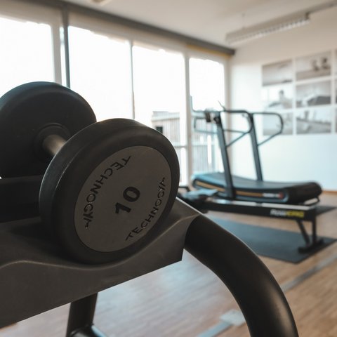 Fitnessraum Dumbbells and treadmill in a bright gym room