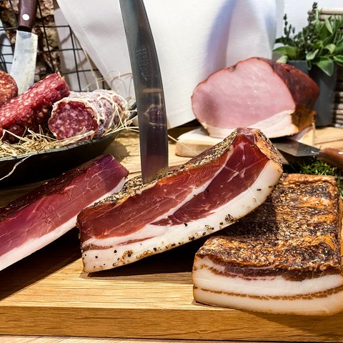 Nachhaltiges Hotel in Bayern mit Hirschenmanufaktur Verschiedene geschnittene Fleisch- und Wurstwaren auf Holzbrett