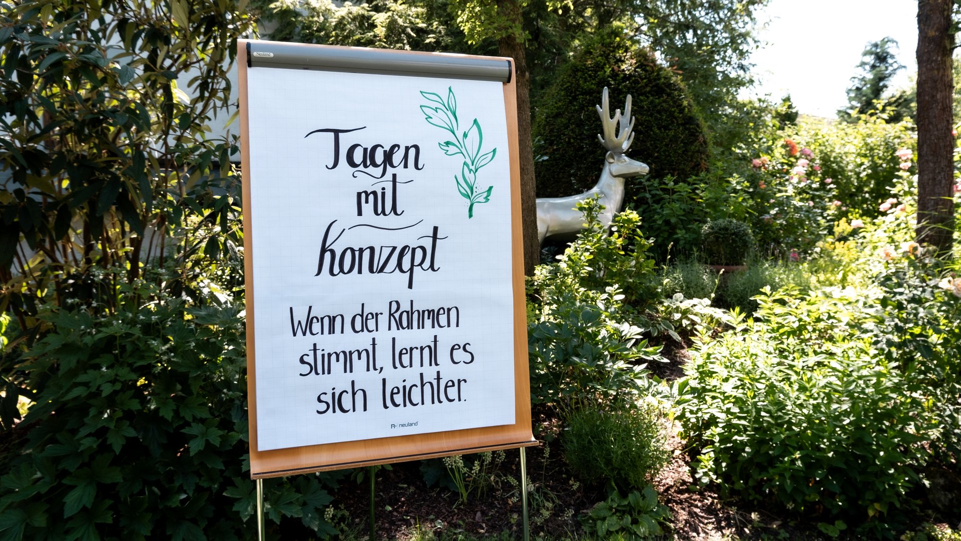 Looking for somewhere for conferences in Bavaria? Flipchart with handwritten quote in a garden with a sculpture