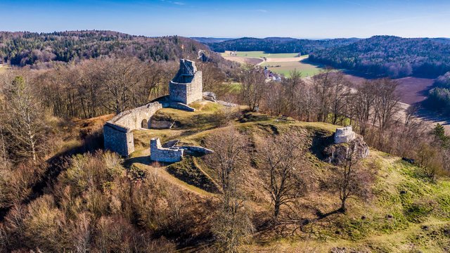 Romantik Hotel Hirschen: Blog Luftaufnahme der Burgruine auf einem bewaldeten Hügel mit blauem Himmel