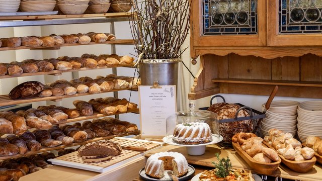 Nachhaltige Hotels in Deutschland gesucht? Verschiedene Brotsorten und Kuchen in einer gemütlichen Bäckerei