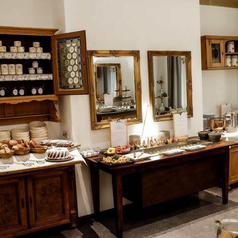 Romantik Hotel Hirschen: Frühstück Rustikales Buffet mit Gebäck, Preppen und Dekoration in einem gemütlichen Raum