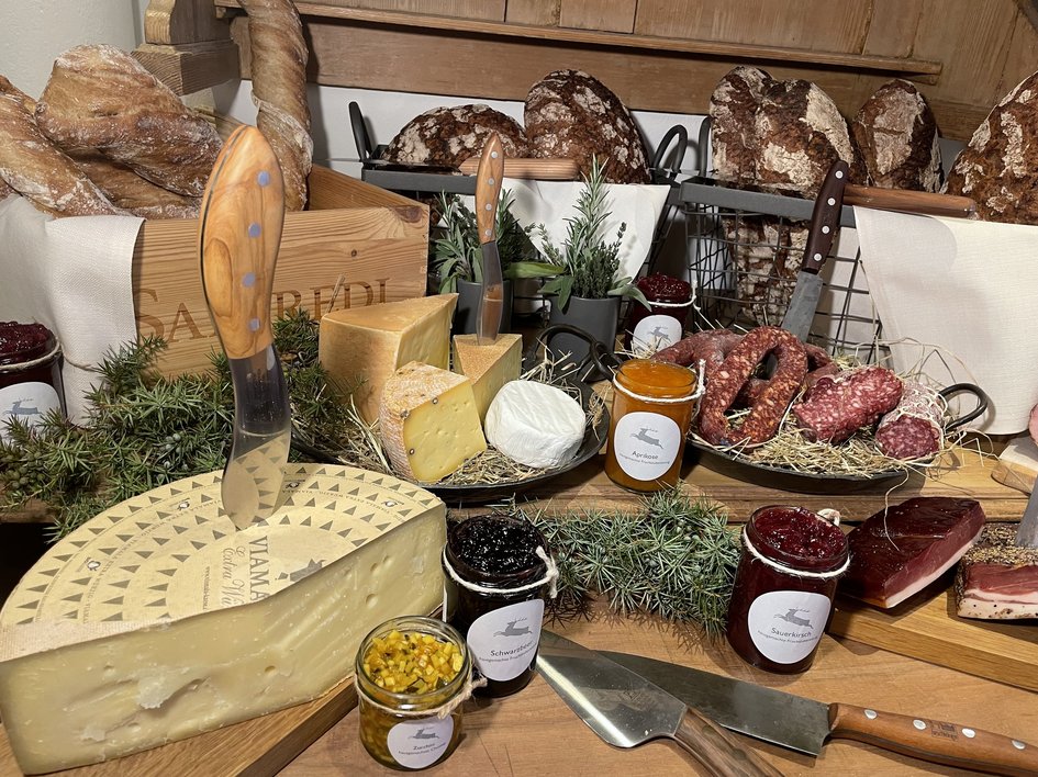 Guesthouse in Parsberg: A salute to great taste Selection of cheese, bread, sausages and jams on wooden table with knives